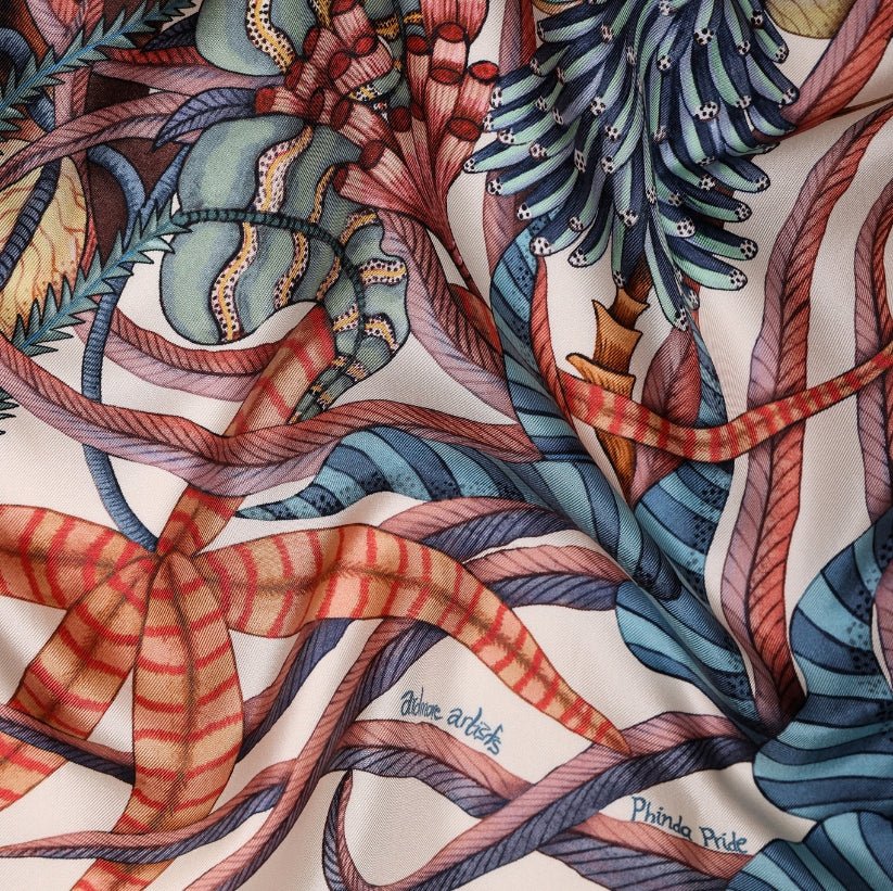 A close-up of the scarf draped naturally, showcasing the silky texture, rich colours, and detailed botanical illustrations.