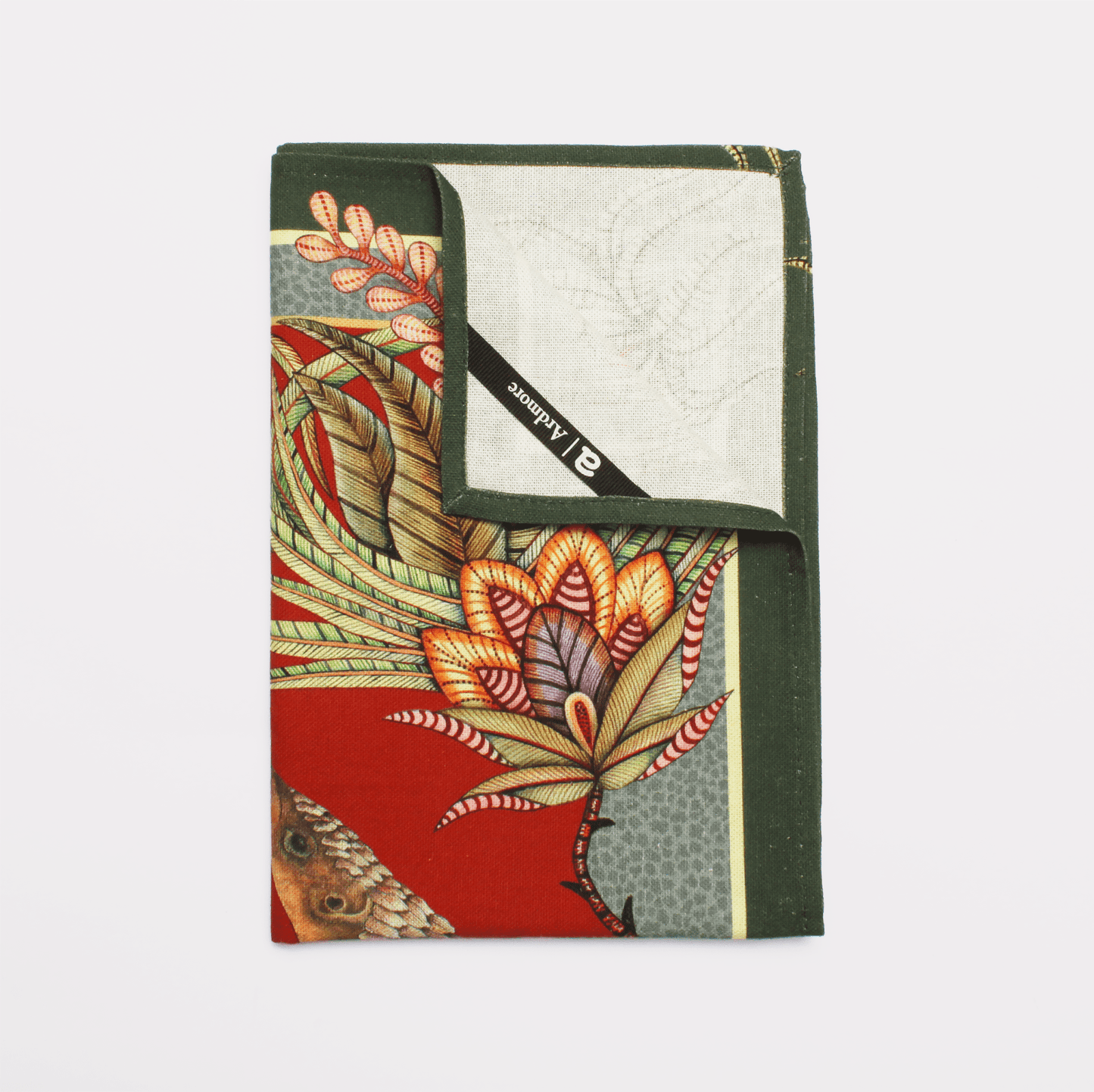 A close-up of stacked tea towels displaying detailed pangolin illustrations intertwined with lush foliage and floral patterns.