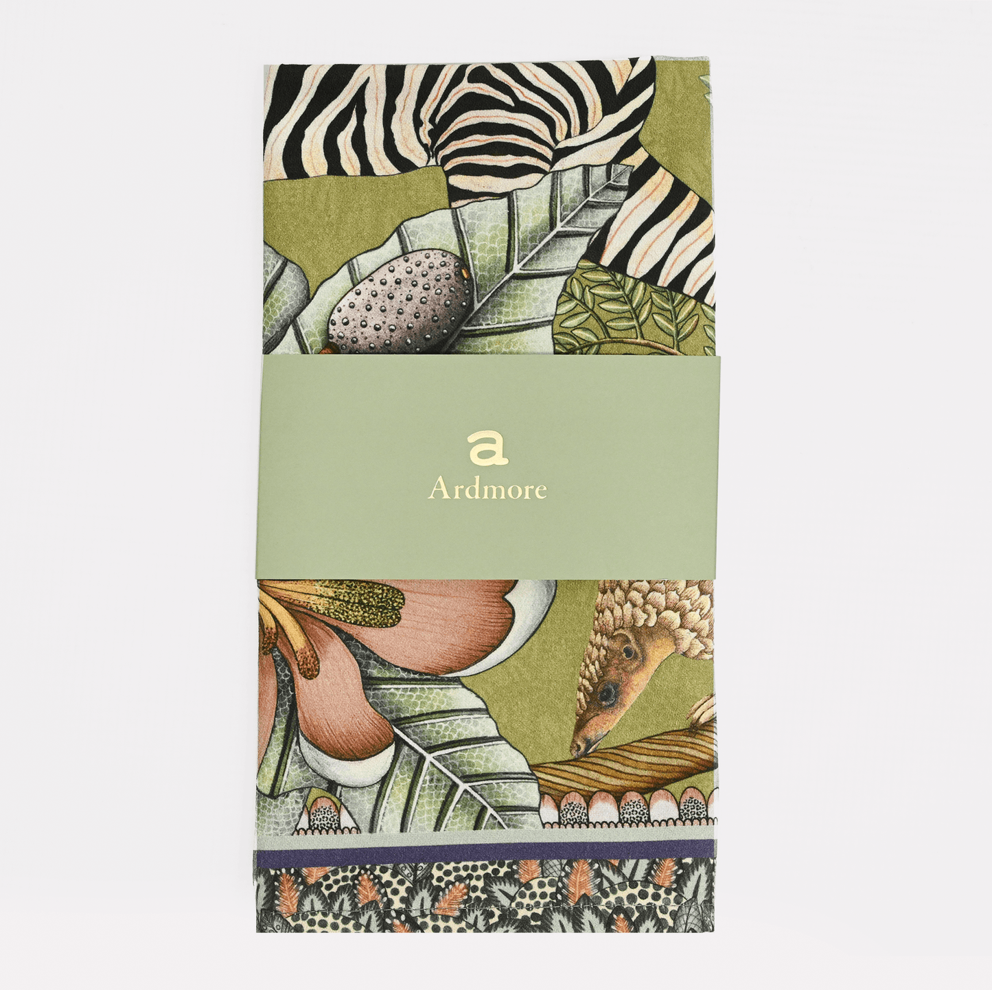 A neatly folded and packaged Ardmore Thanda Stripe Napkin in Delta, wrapped with a branded paper band, emphasizing the luxurious craftsmanship and artistic heritage.