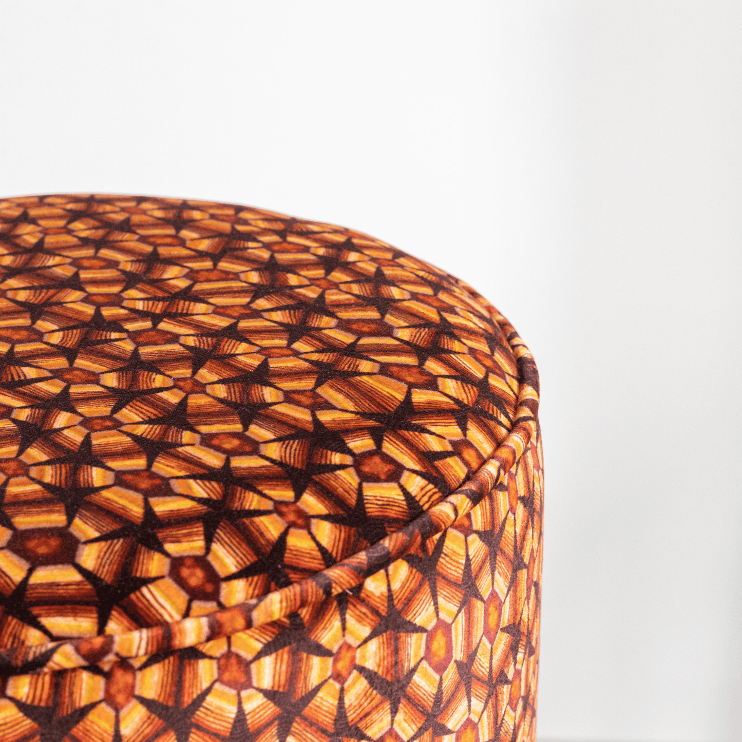 A detailed shot highlighting the intricate craftsmanship, warm plum tones, and self-fabric piping that adds a refined touch.