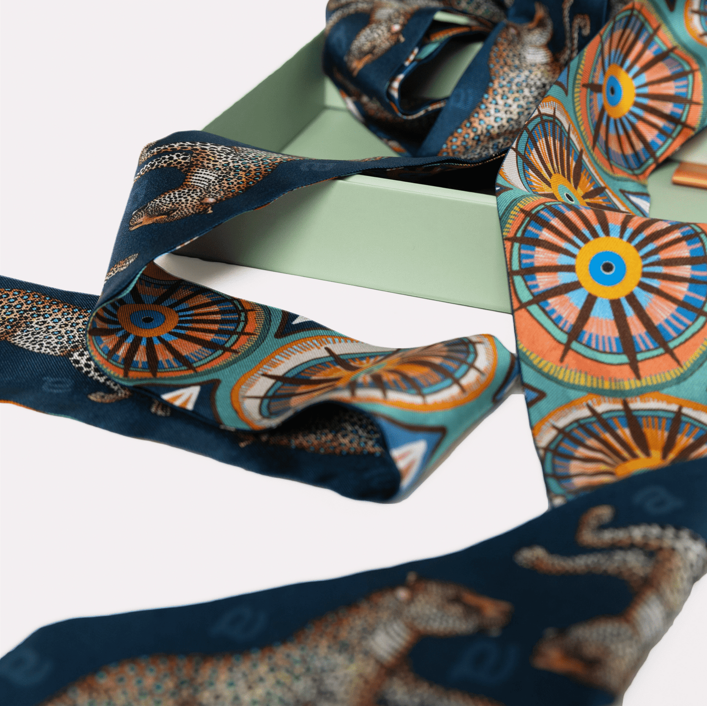 The twilly wrapped around a black handbag handle, adding a refined and fashionable touch to the accessory.