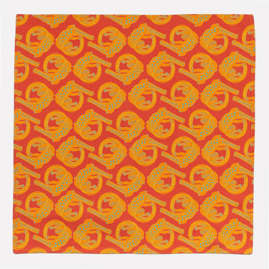 A full view of the Ardmore Croco napkin in Sunset, showcasing the intricate crocodile-inspired pattern in vibrant orange and golden hues, reminiscent of an African sunset.