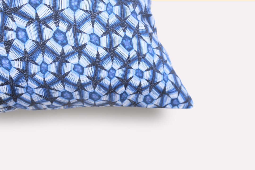 Close-up of the Thanda Tortoise Tanzanite Cushion Cover, highlighting the intricate blue patterned design and fabric texture on the cushion's corner.