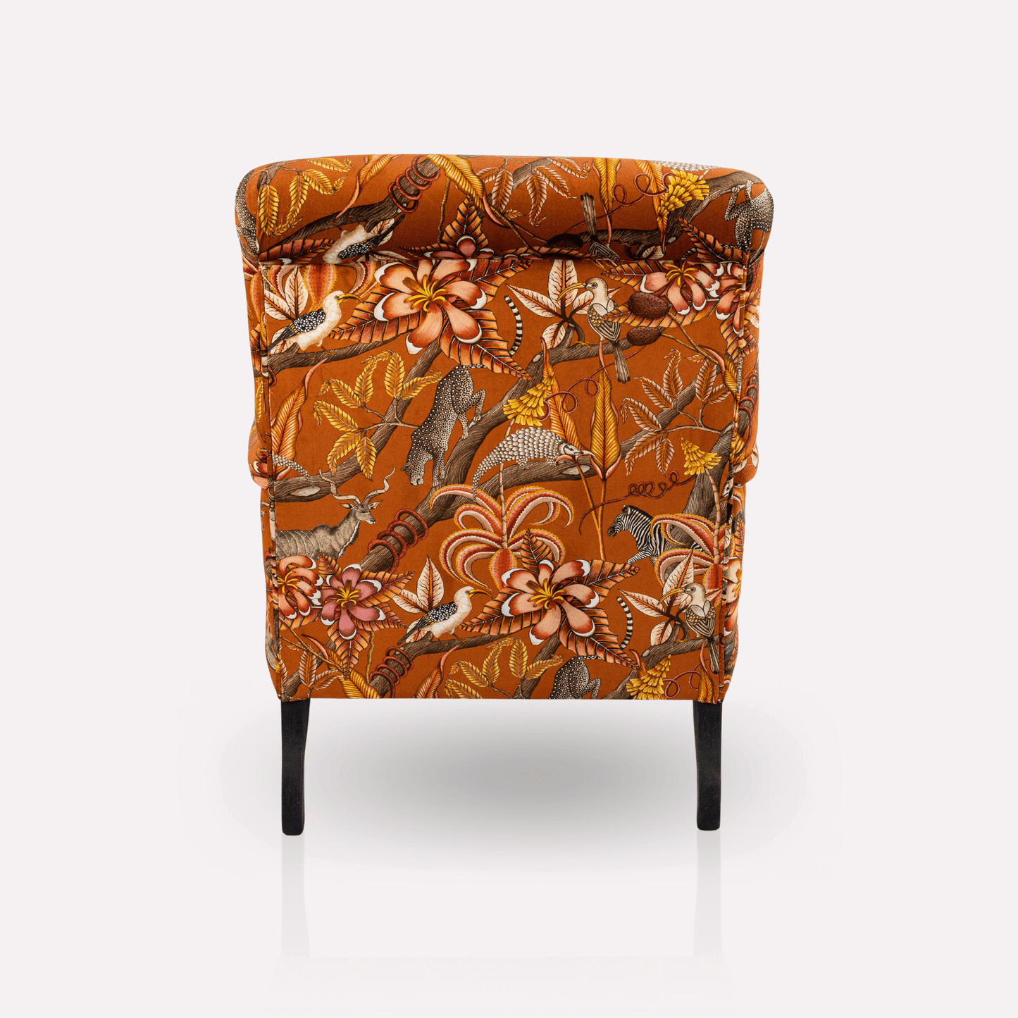 Rear view of the Ardmore Kudu Pod Chair in Pangolin Park Rust Velvet, highlighting the seamless fabric finish and sturdy black wooden legs.