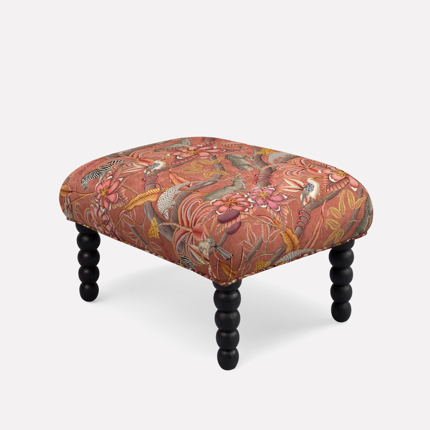 Ardmore Kudu Pod Ottoman in Pangolin Park Rust Velvet, featuring a warm-toned botanical pattern in earthy reds and oranges, with black spindle legs, blending African-inspired artistry with contemporary luxury.