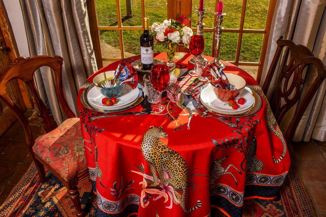 A full dining room setup showcasing the tablecloth in a luxurious setting, surrounded by elegant tableware and ambient décor.