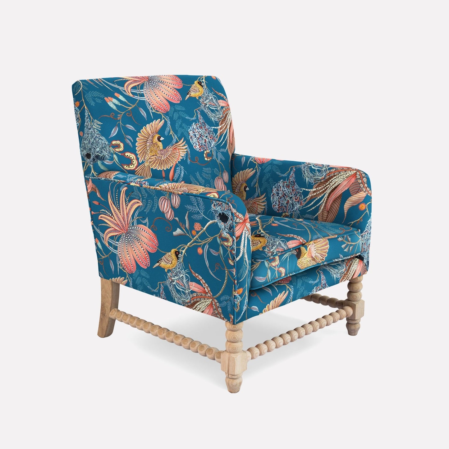 A side view of the Lucky Bean Chair, showcasing its solid wooden frame and intricate velvet upholstery. The fabric’s rich blue tones are accentuated with tropical floral and wildlife motifs, blending contemporary elegance with traditional African craftsmanship.