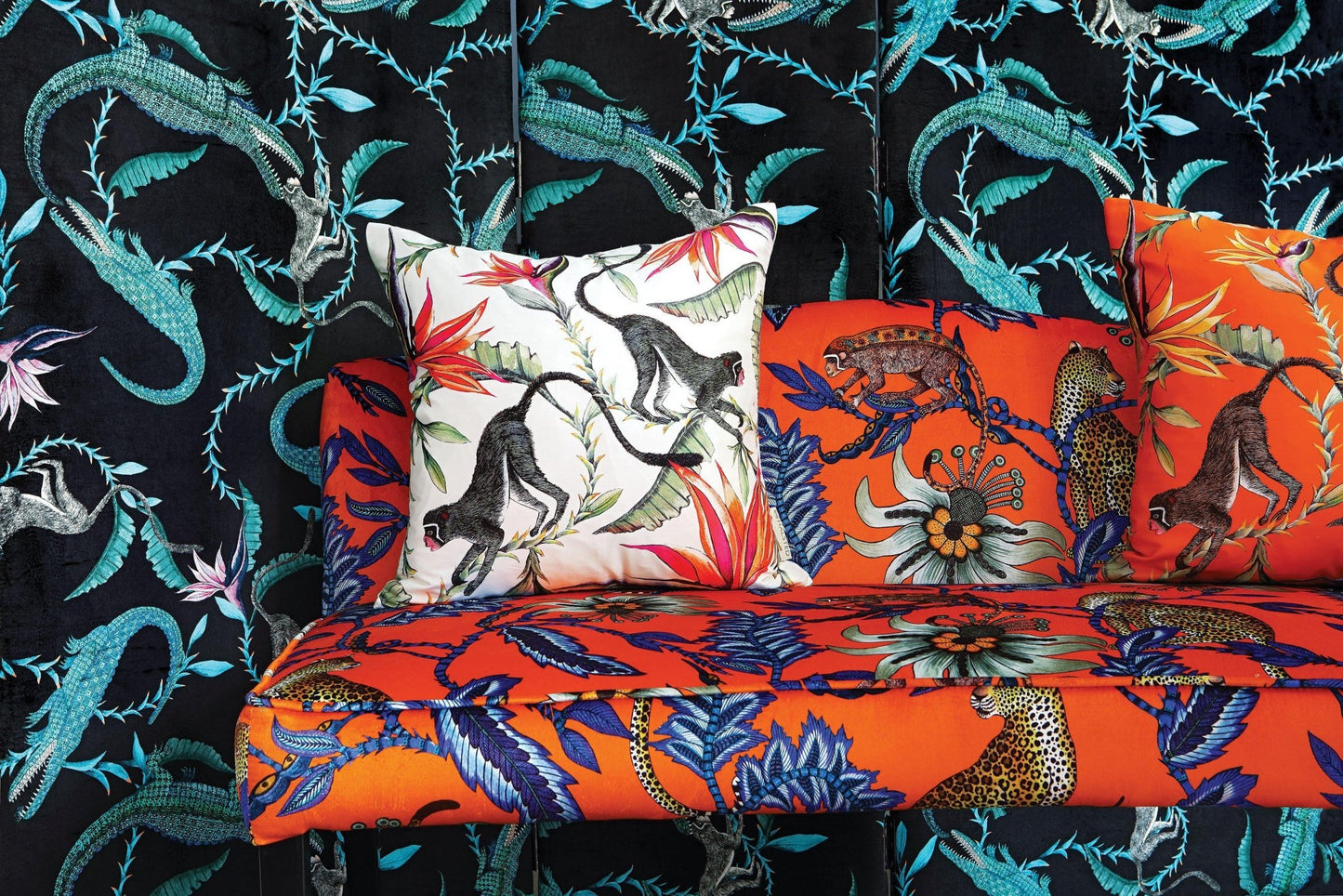 Stylised display of the Monkey Paradise Chalk Cushion Cover alongside other vibrant cushion designs in a decorative setup.