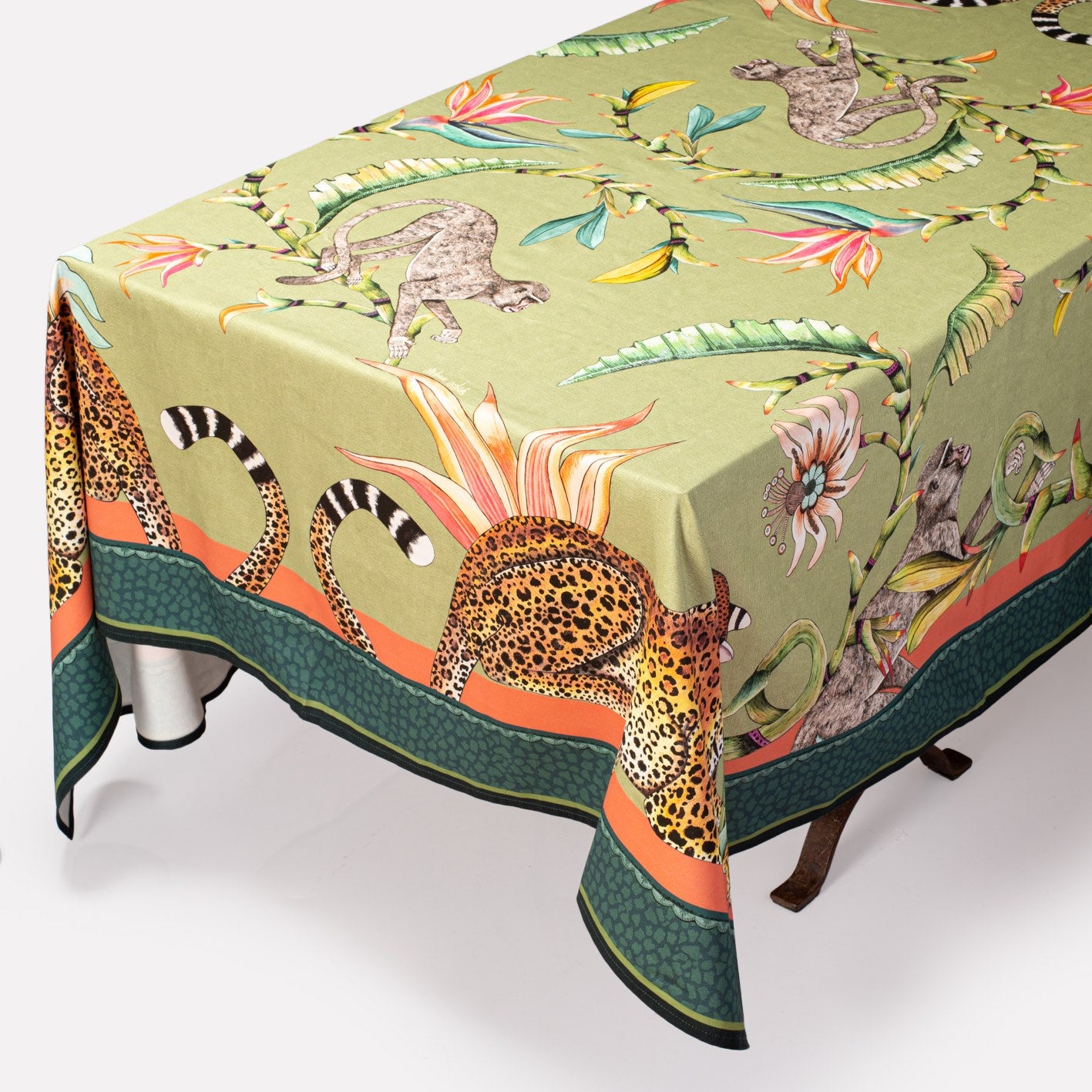 A close-up of the tablecloth draped over a table, showcasing the intricate patterns and animal motifs.