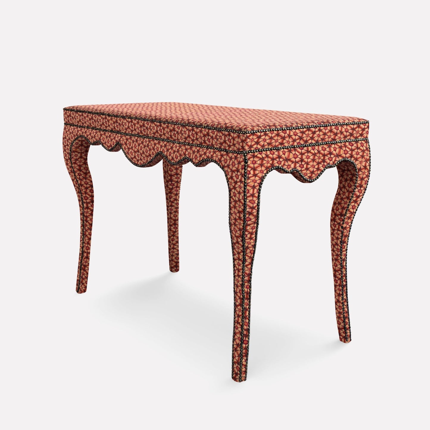 A side-angle view of the Nyala Table, showcasing its curved, ornate legs and the rich, textured fabric enveloping the structure. The deep plum tones and intricate tortoise shell-inspired pattern add a sophisticated and artistic touch to any interior.