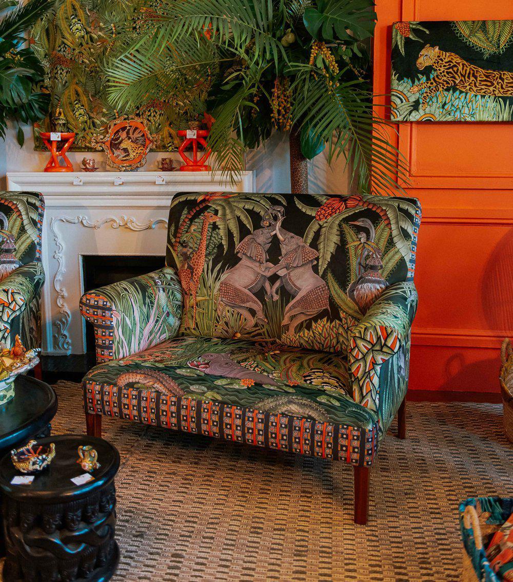 Sofa displayed in a boutique showroom, illustrating its rich colour palette and detailed textile design.