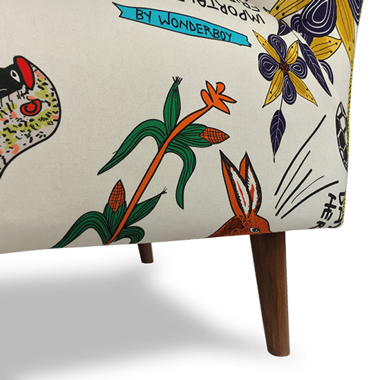 A macro shot of the wooden legs and fabric texture, emphasising the craftsmanship of the upholstery and the detailed artistic prints that make each chair unique.