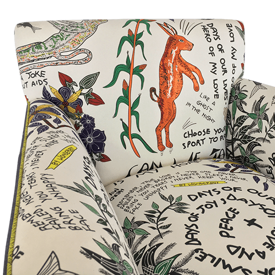 A close-up shot of the backrest, displaying elements of the hand-drawn illustrations, including African wildlife, figures, and script-style text woven into the design.