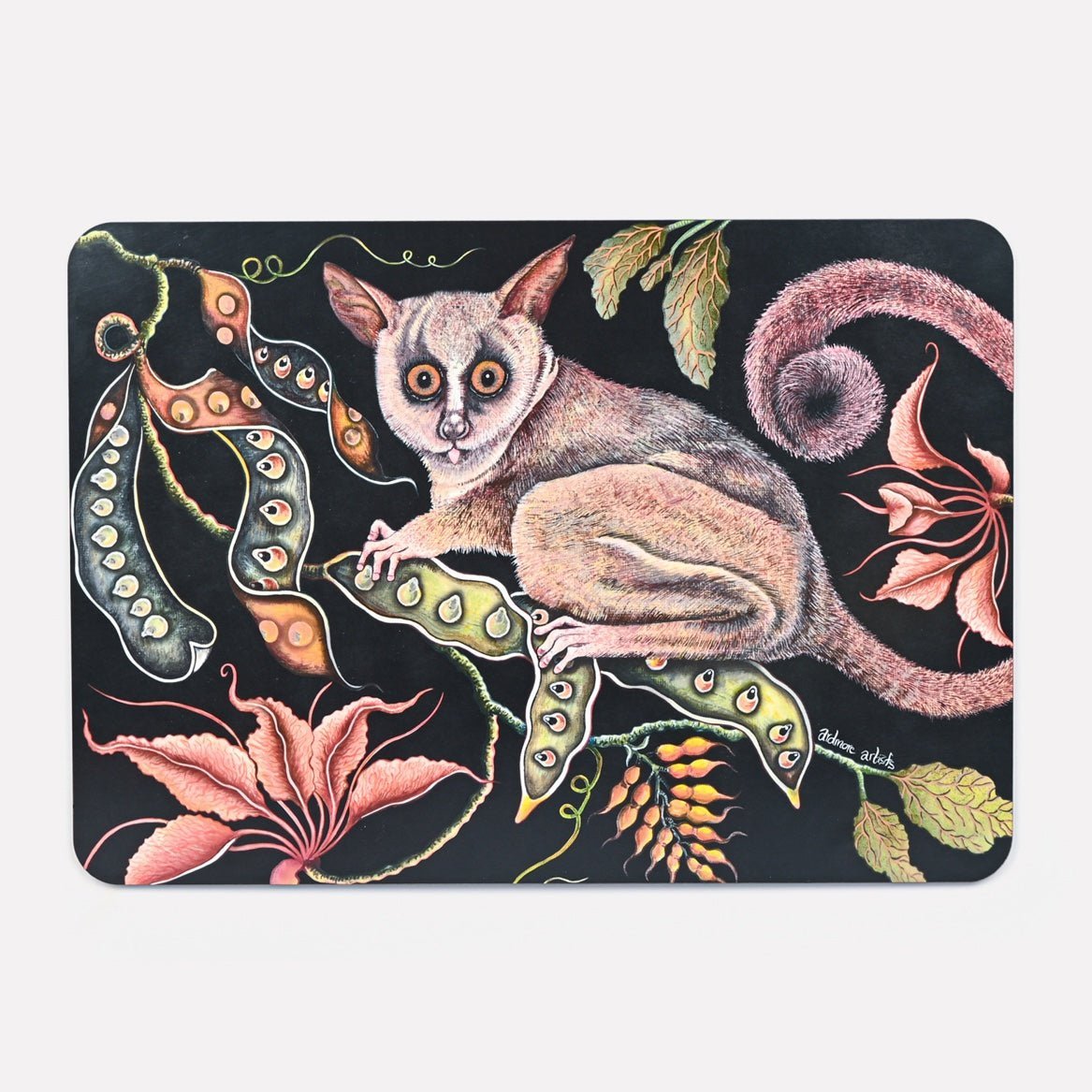A hardboard placemat featuring a detailed illustration of a bush baby with large, glowing eyes, surrounded by lush foliage and exotic flowers against a dark background.