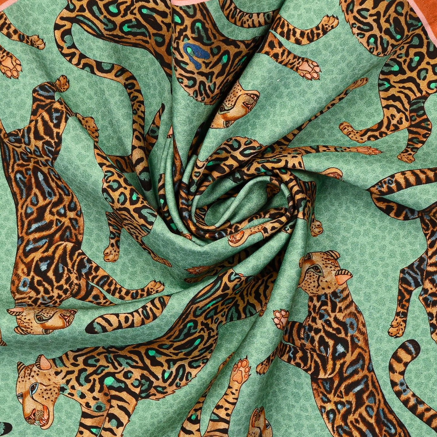 An extreme close-up of the Ardmore Cheetah King napkin in Jade, capturing the intricate cheetah illustration, rich cotton texture, and vibrant hues.