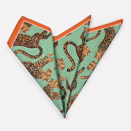 A set of Ardmore Cheetah King napkins in Jade, neatly folded to highlight the elegant cheetah motif and the refined blend of jade, turquoise, and gold hues.
