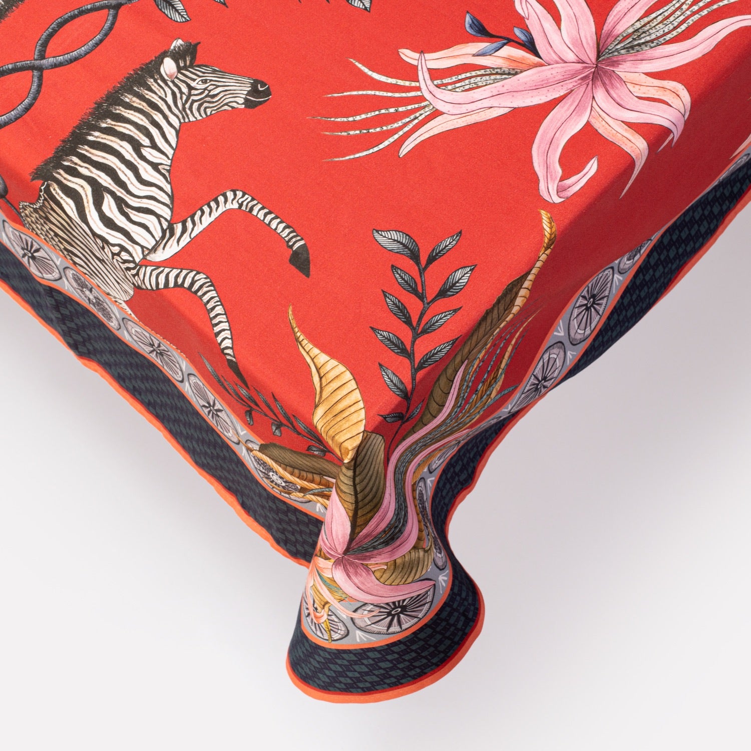 A detailed close-up of the tablecloth’s corner, showcasing the vibrant red fabric, floral accents, and a seamless pattern transition.