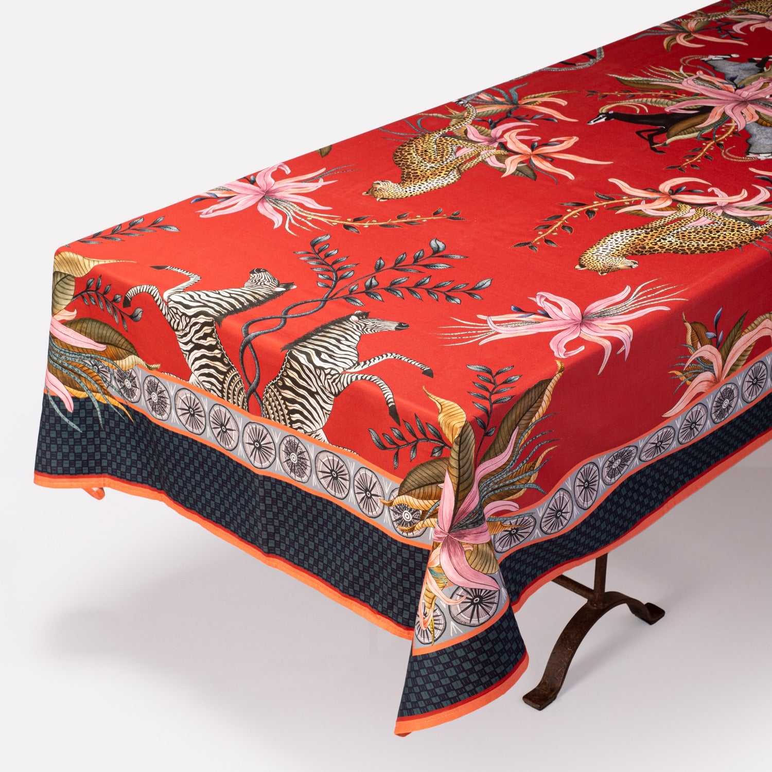 The Leopard Lily Tablecloth in Royal Red elegantly draped over a table, displaying its premium cotton texture and refined pattern.