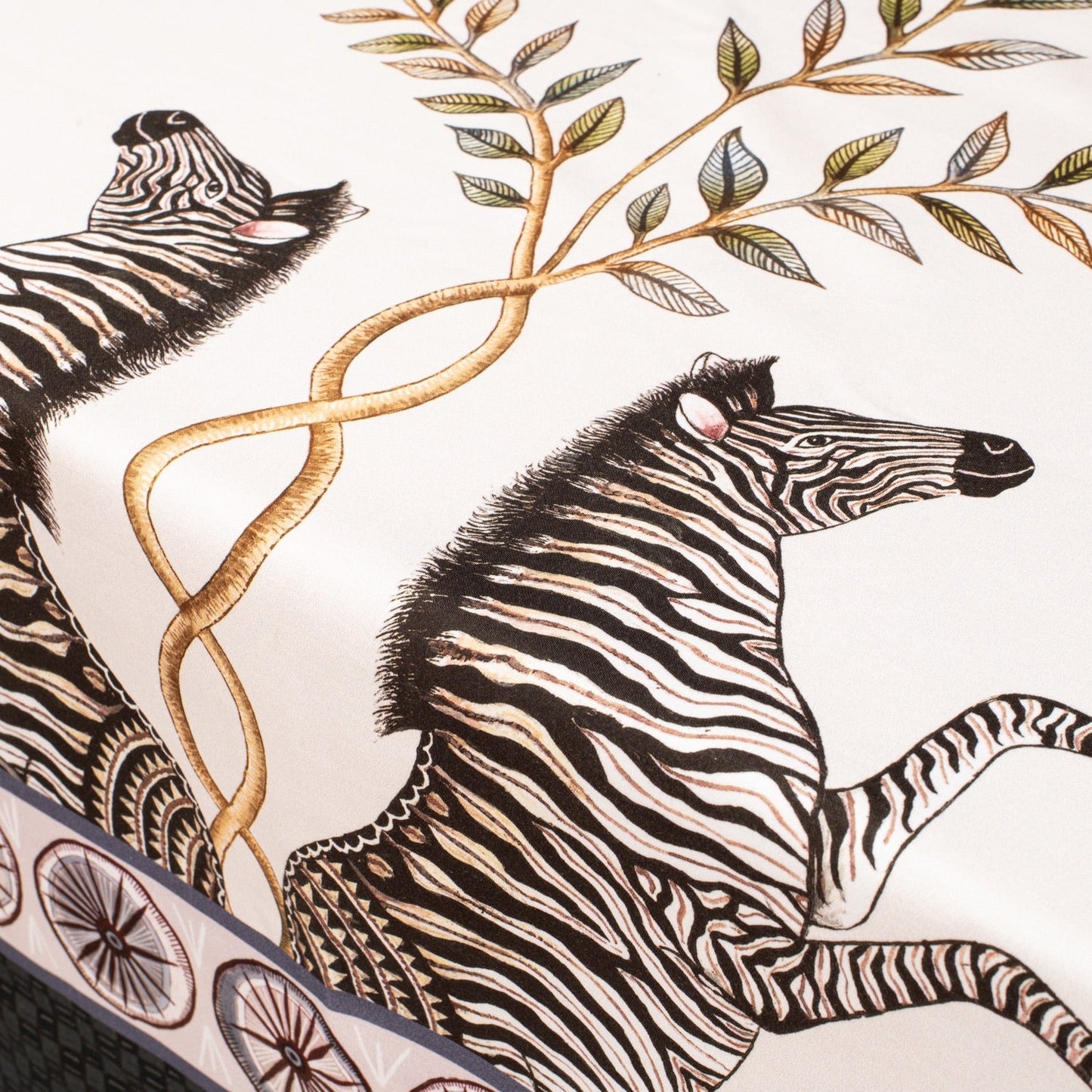 A focused shot on a portion of the tablecloth, showing the smooth draping and harmonious blend of florals and safari wildlife.