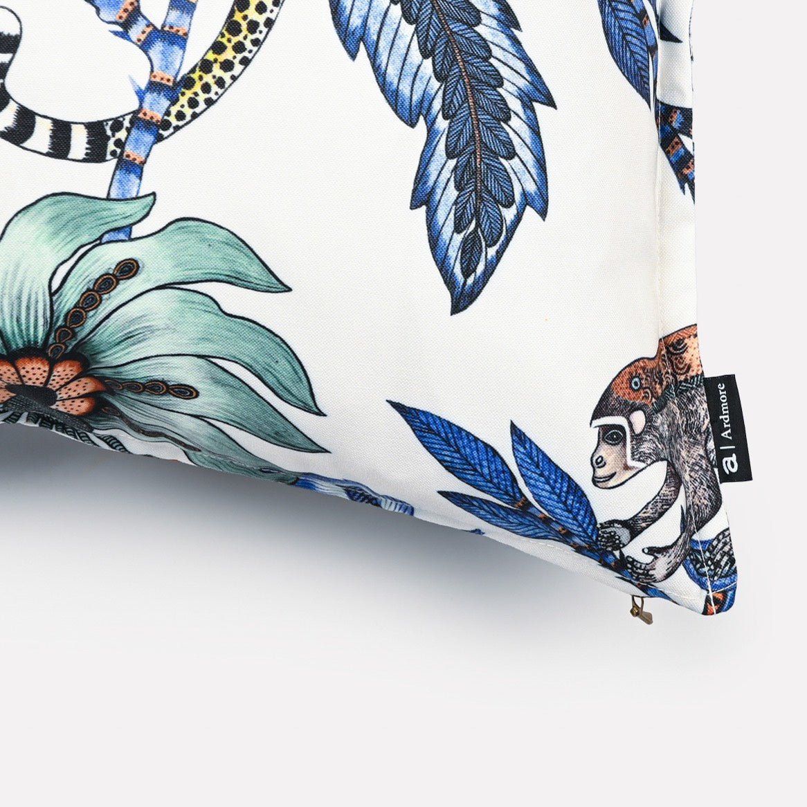 Close-up of the Monkey Bean Tanzanite cushion cover, focusing on a bold floral motif surrounded by intricate blue foliage and a leopard tail detail.