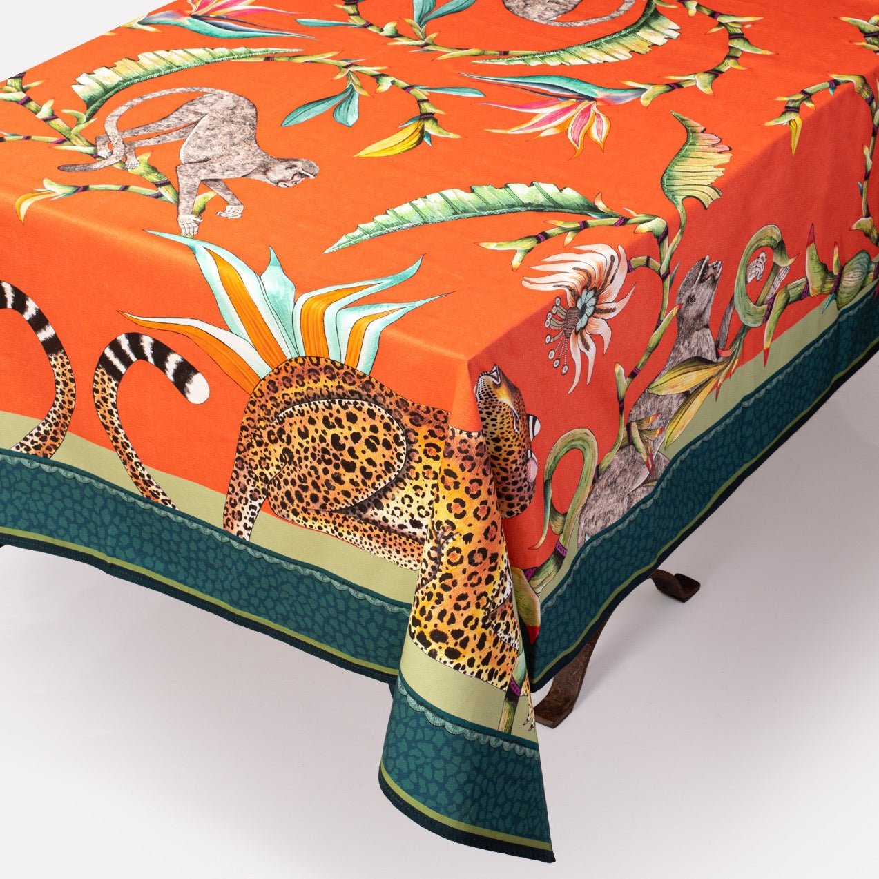 A detailed view of the tablecloth’s intricate border and fabric texture as it drapes over the table’s edge.