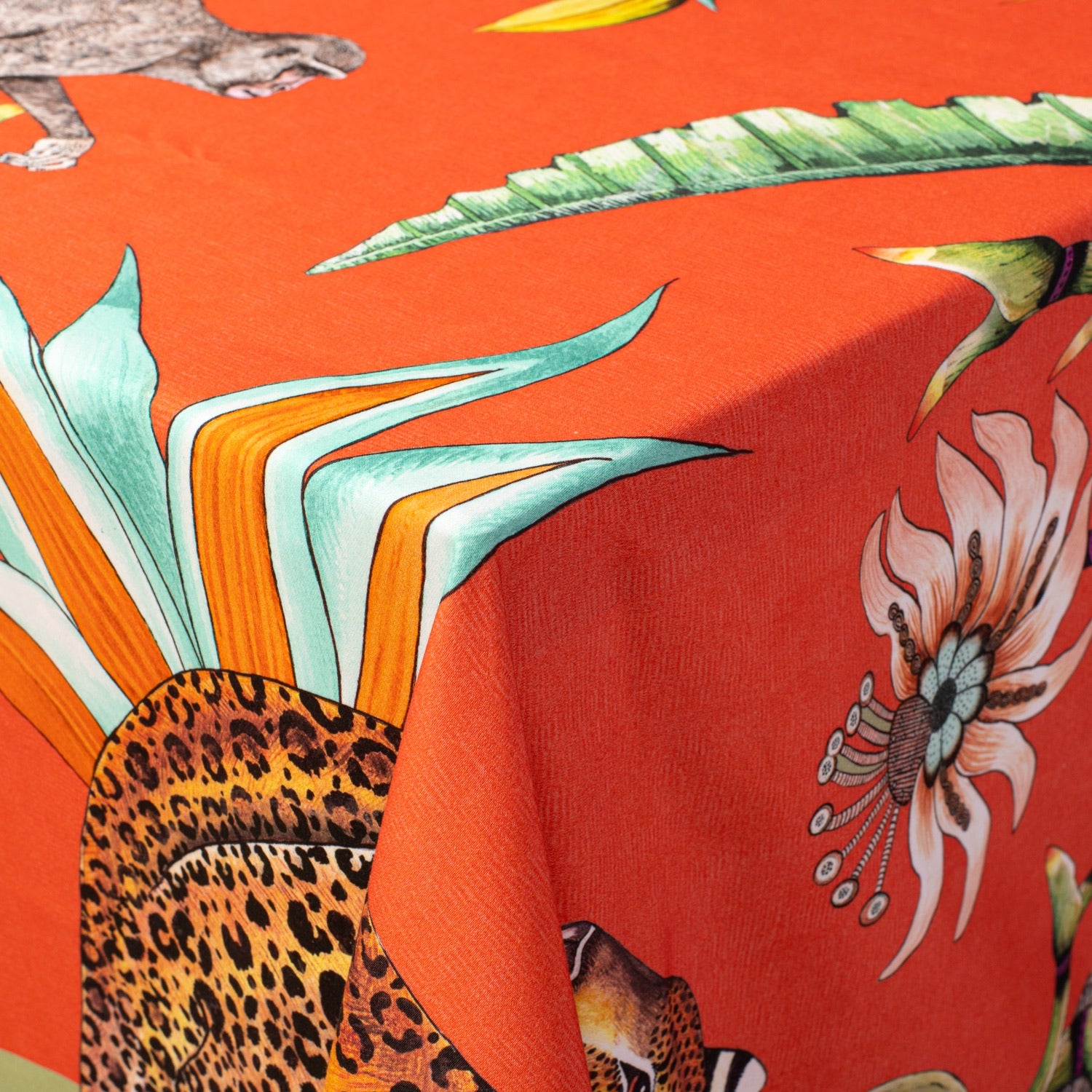 A macro shot highlighting the tablecloth’s depiction of a majestic leopard amidst lush tropical foliage.