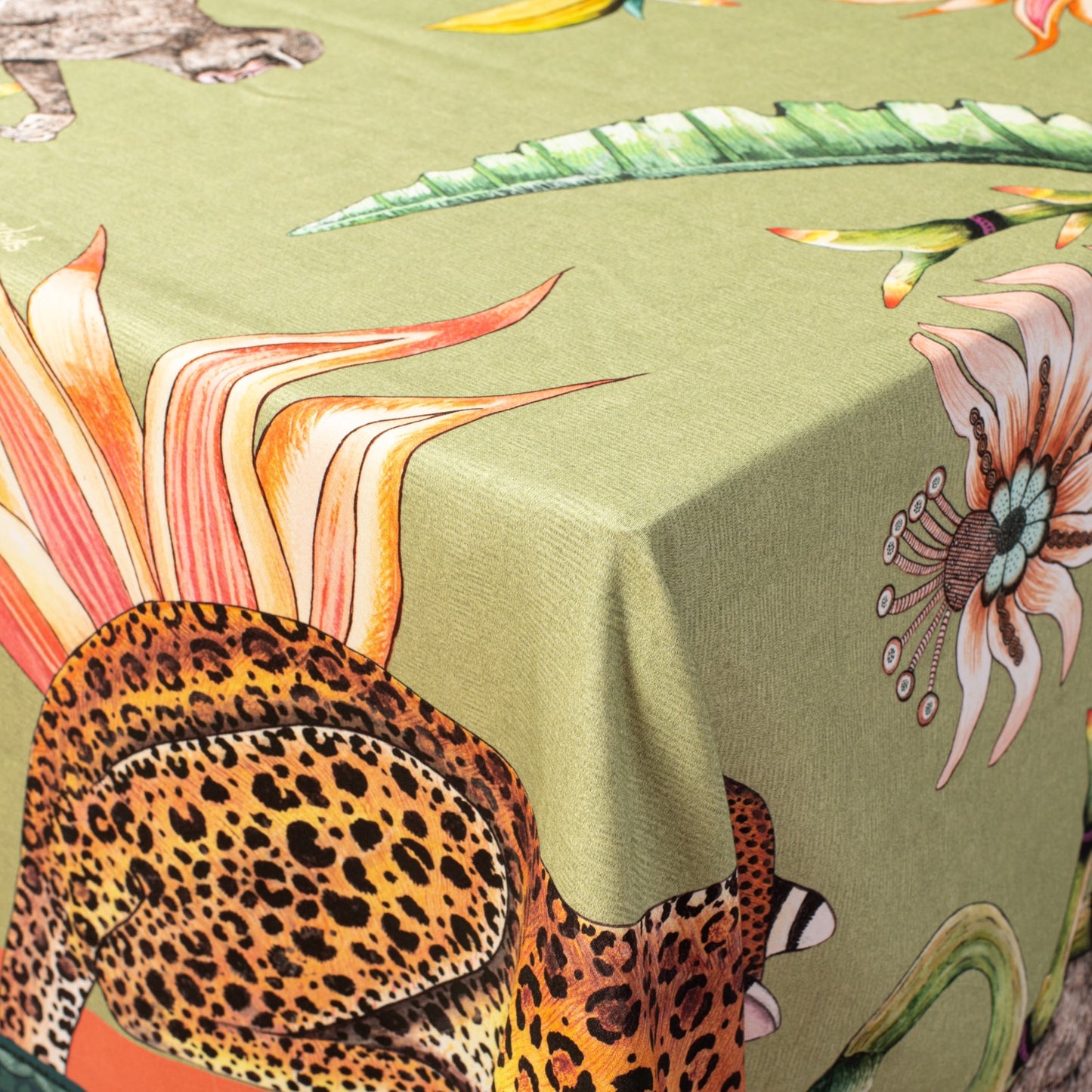 A detailed close-up of a leopard among exotic flowers and foliage on the tablecloth.