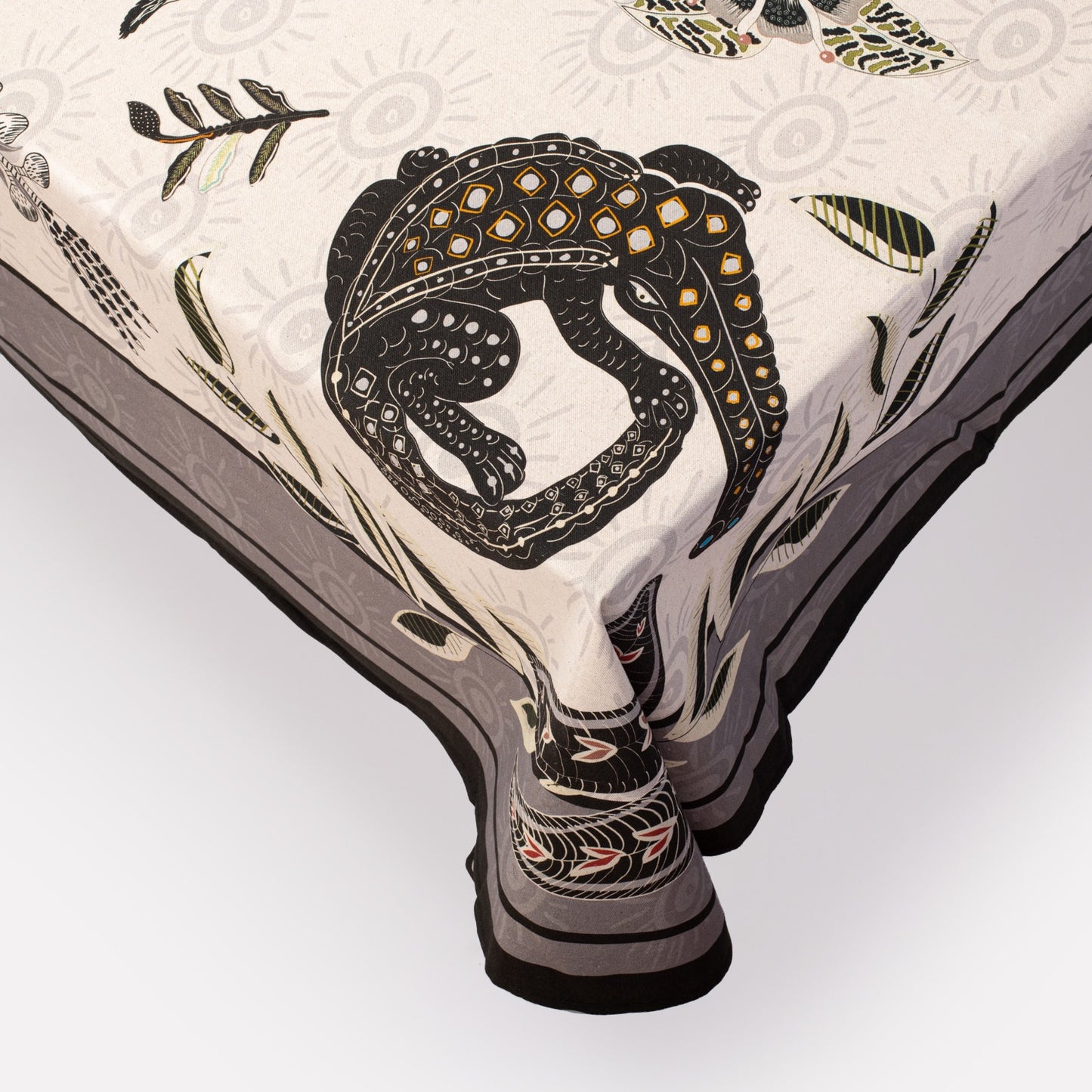 A close-up of the tablecloth’s corner, showing the graceful drape, fine fabric texture, and the bold leopard print design.