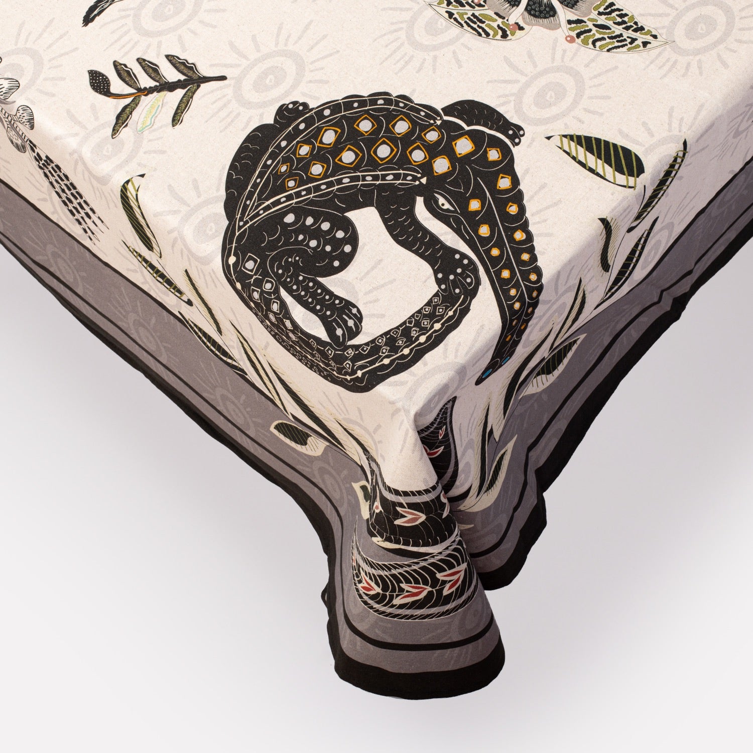 A close-up of the tablecloth’s corner, showing the graceful drape, fine fabric texture, and the bold leopard print design.