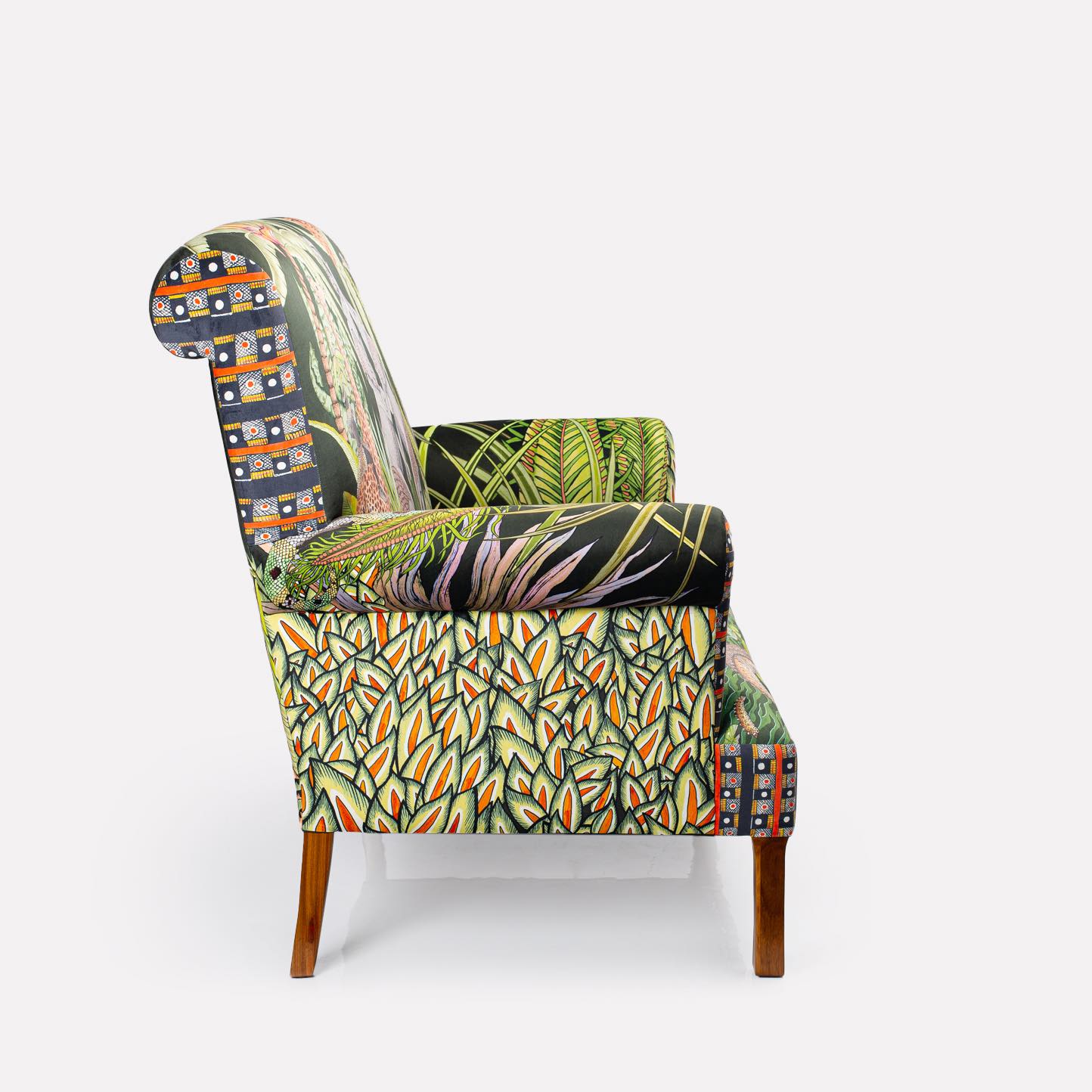 Side view of the Ardmore Sabie Sofa, displaying the stunning jungle-inspired fabric with rich botanical and animal motifs.