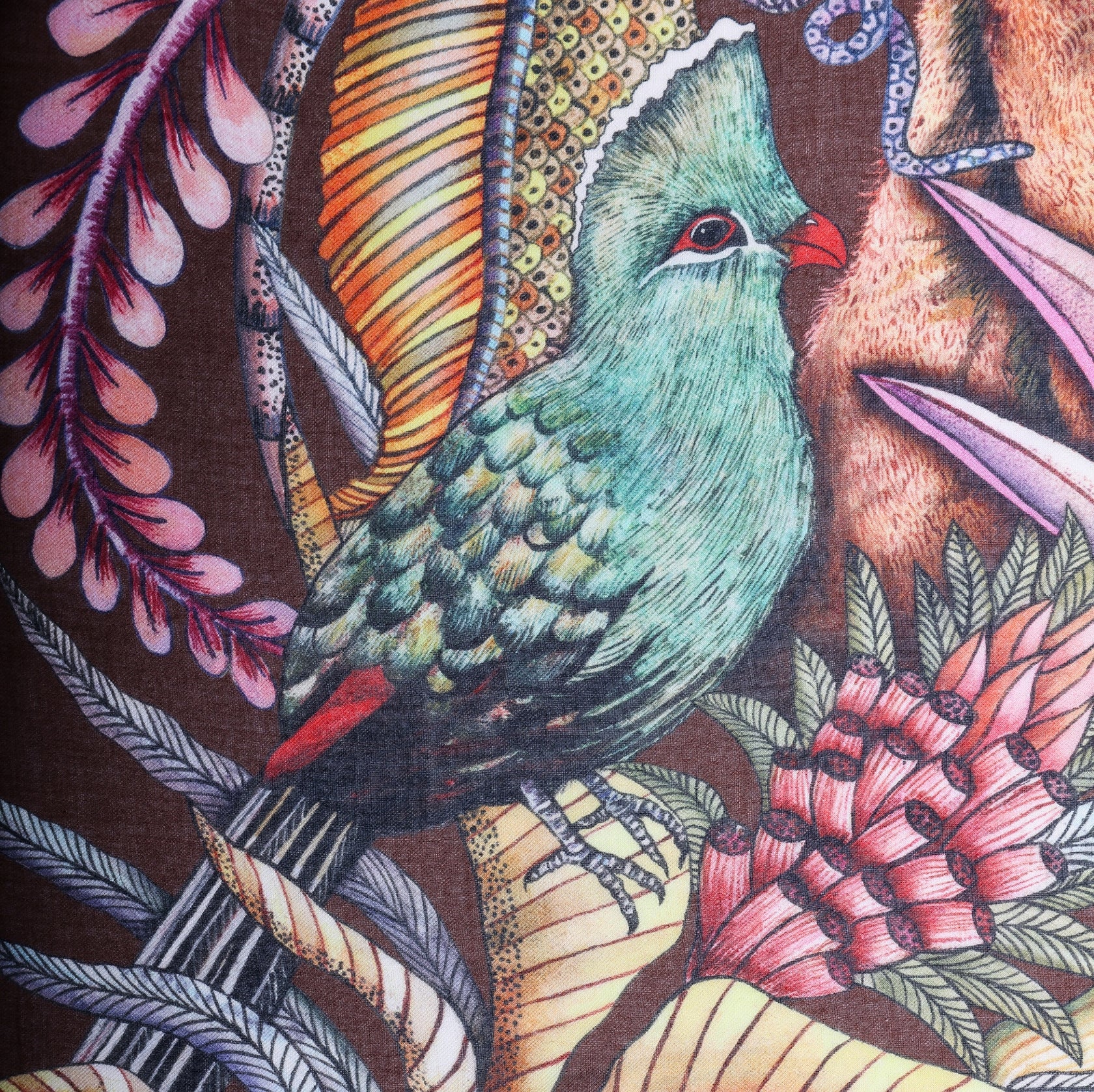 A vibrant turquoise turaco bird perched among detailed foliage, blending with the earthy tones of the scarf.