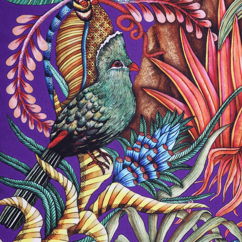 A vibrant turquoise turaco bird nestled among the foliage, adding a dynamic pop of colour to the scarf’s intricate design.