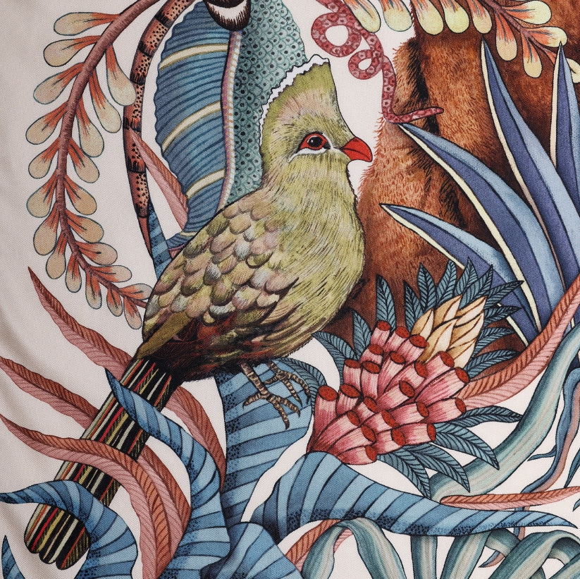 A zoomed-in section highlighting a beautifully painted green loerie bird perched among delicate branches and foliage.