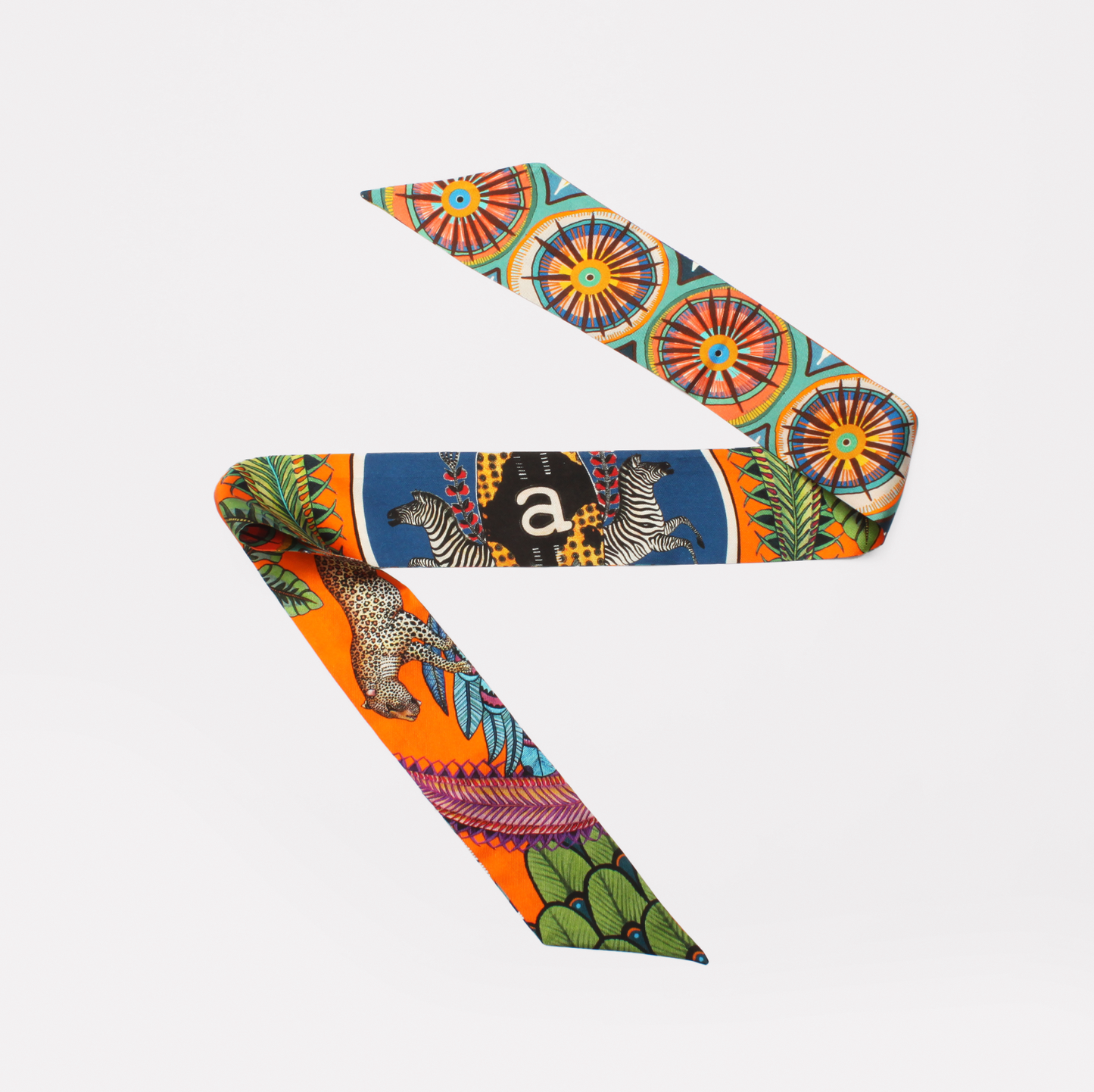 A luxurious silk twill ribbon featuring vibrant African-inspired Amasumpa prints and intricate fauna and flora motifs in warm flame hues, elegantly displayed against a white background.