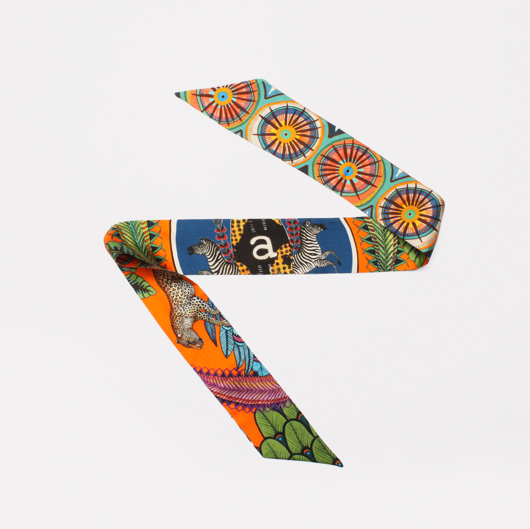 A luxurious silk twill ribbon featuring vibrant African-inspired Amasumpa prints and intricate fauna and flora motifs in warm flame hues, elegantly displayed against a white background.
