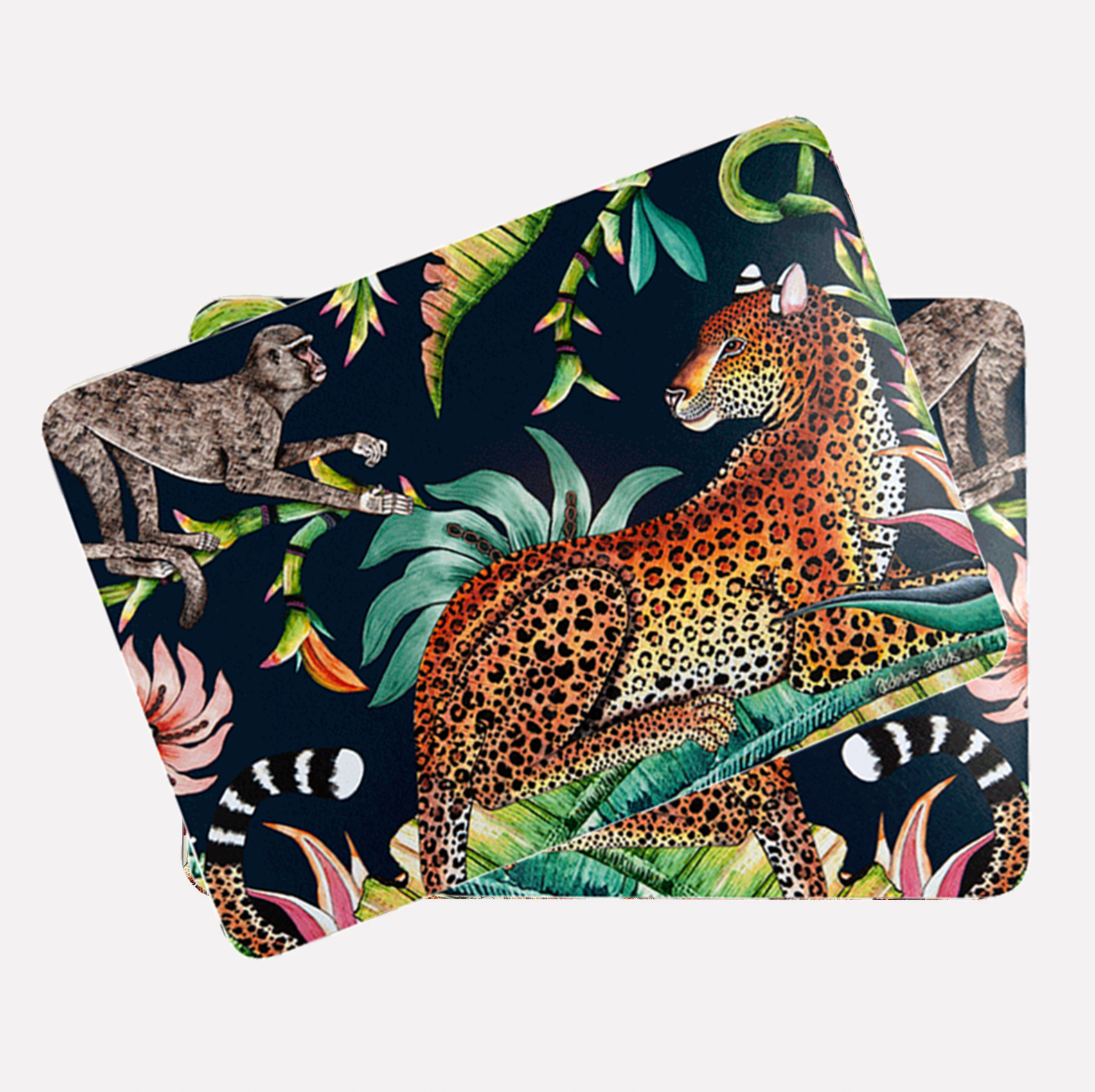 A pair of placemats neatly stacked, displaying the leopard and monkey motif along with intricate botanical details.