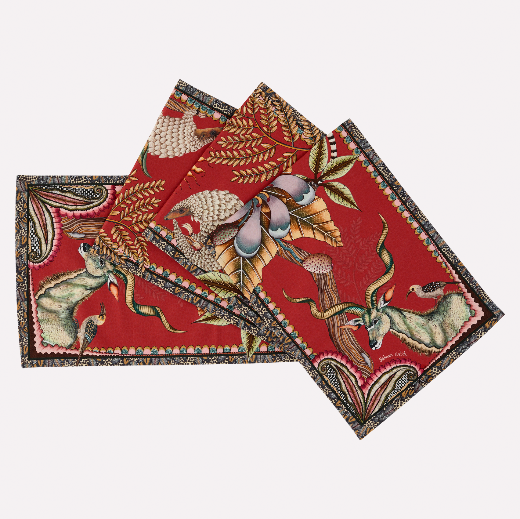 A neatly arranged set of Ardmore's Pangolin Park Table Runners in Royal Red, featuring a rich red background with intricate depictions of wildlife and foliage.