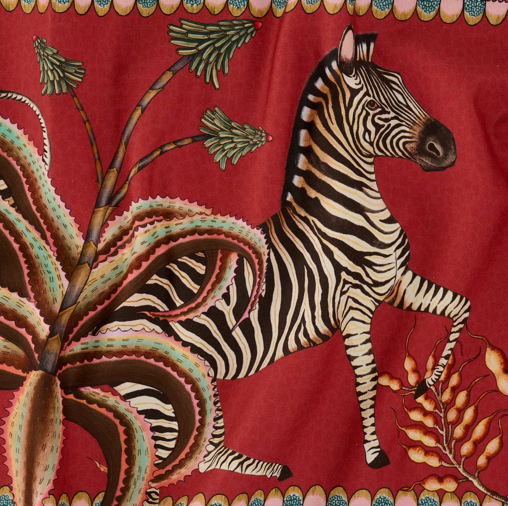 A tightly cropped shot of the table runner, focusing on the bold zebra illustration woven into the intricate design.