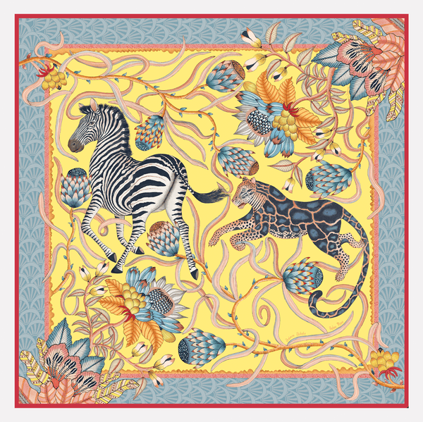 A luxurious oversized silk scarf featuring a vibrant African-inspired design with zebras, leopards, and protea flowers in a bold yellow, blue, and coral palette.