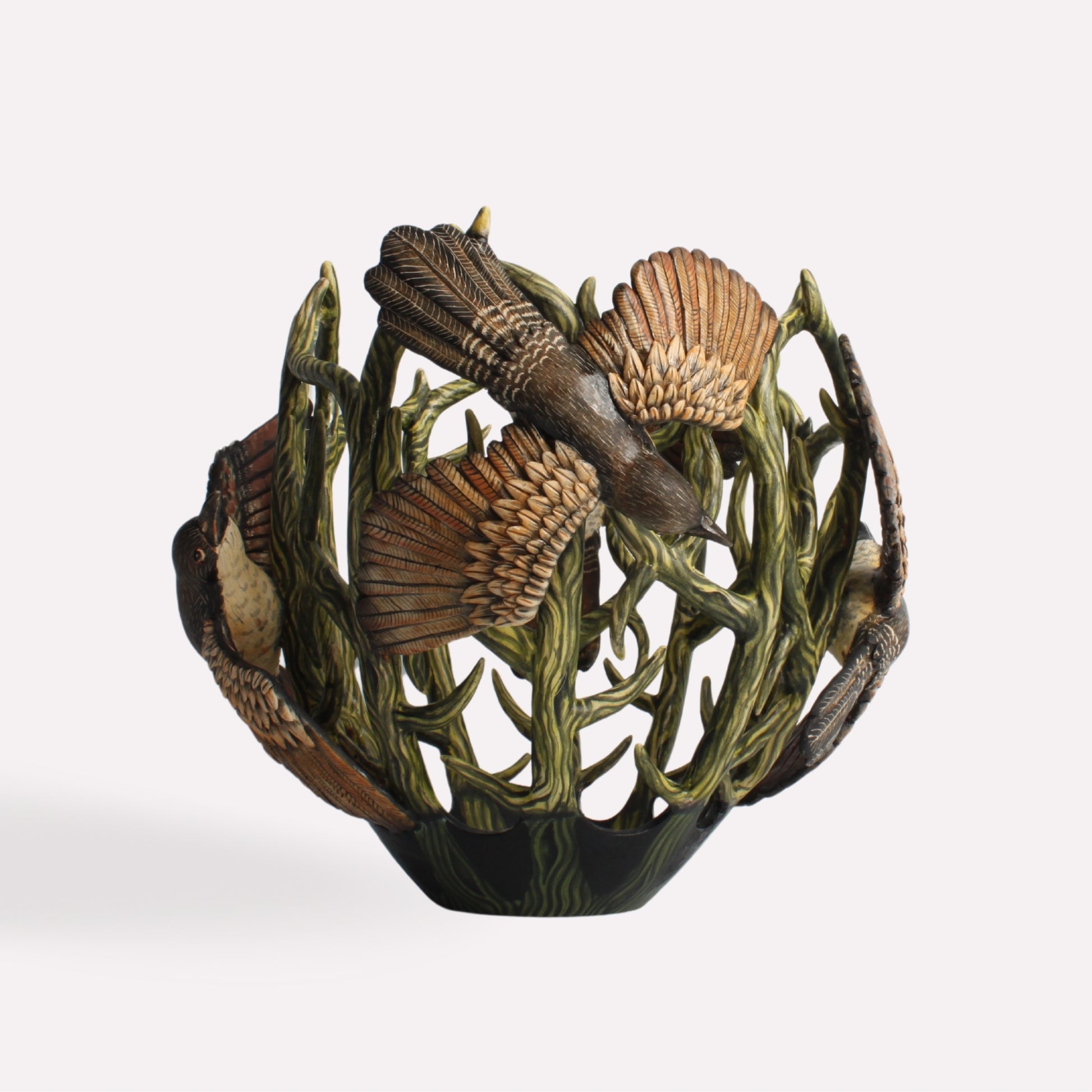 A side perspective showcasing the vessel’s openwork structure, allowing glimpses of its depth and three-dimensional artistry. The detailed wings of the coucal birds extend slightly, adding texture.