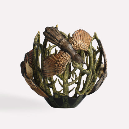 A side perspective showcasing the vessel’s openwork structure, allowing glimpses of its depth and three-dimensional artistry. The detailed wings of the coucal birds extend slightly, adding texture.