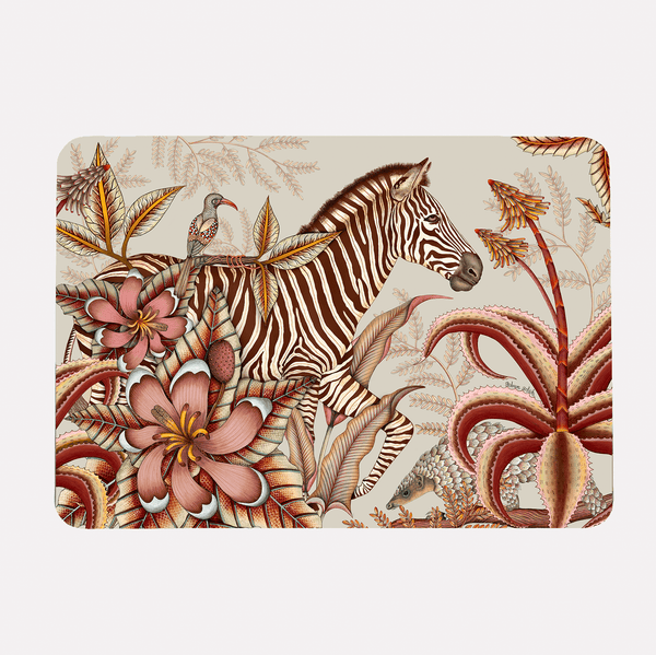 A hardboard placemat featuring a zebra surrounded by lush magnolias, flowering aloes, and intricate foliage on a soft plum background.