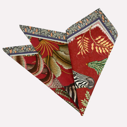 A neatly folded pair of Ardmore Thanda Stripe Napkins in Royal Red, showcasing the intricate African-inspired design with bold red tones, zebra, and floral motifs.