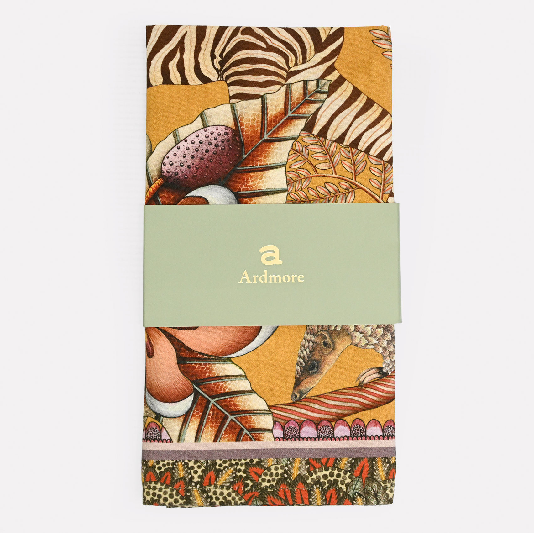 A neatly folded and packaged Ardmore Thanda Stripe Napkin in Magnolia, secured with a branded paper band, emphasizing its premium cotton fabric and exquisite design.