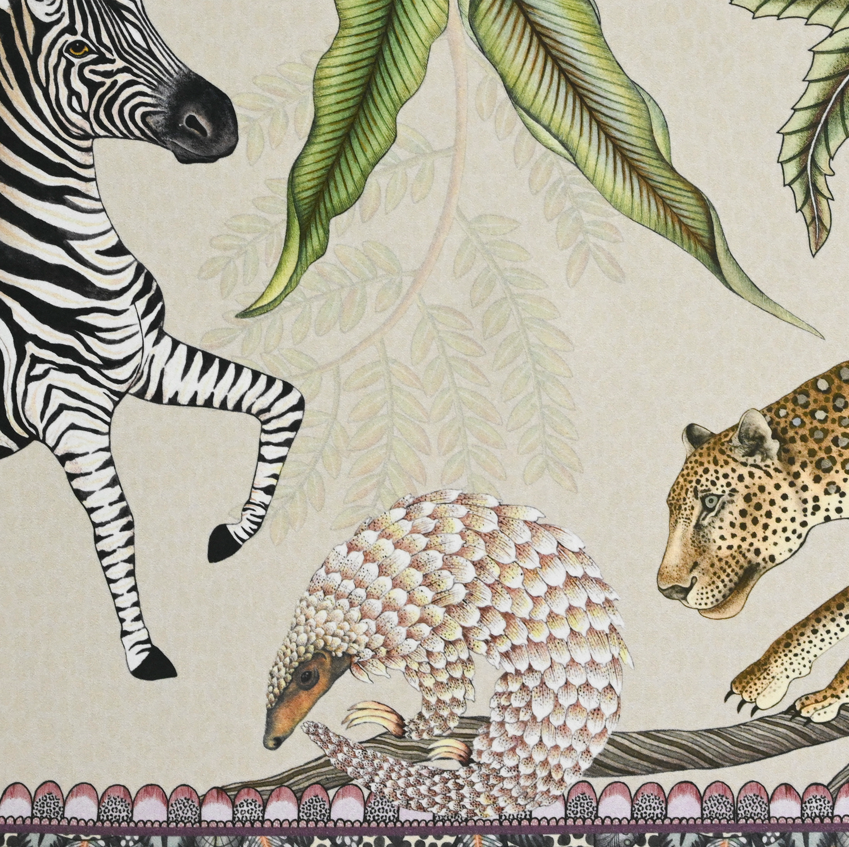 A tightly cropped shot of the table runner, focusing on a finely detailed leopard illustration amid botanical elements.