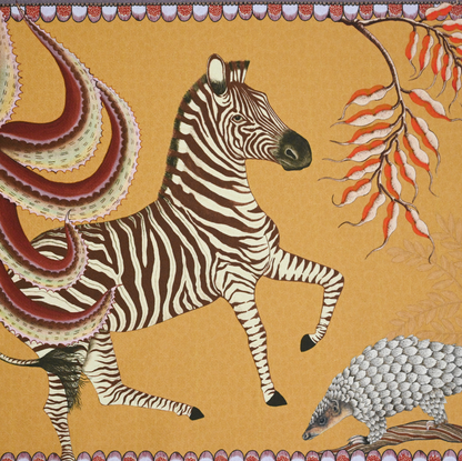 A tightly cropped shot of the table runner, focusing on a striking zebra illustration against the rich golden-orange fabric.