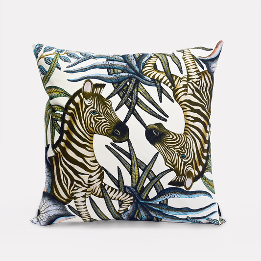 Front view of the Thanda Stripe Tanzanite Cotton Cushion Cover, showcasing a majestic zebra design surrounded by lush African flora on a soft white background, made from 100% cotton.