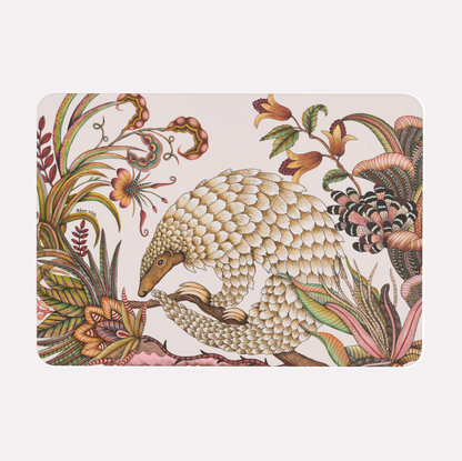 A hardboard placemat featuring an intricate illustration of a golden pangolin amidst detailed floral and botanical patterns on a white background.