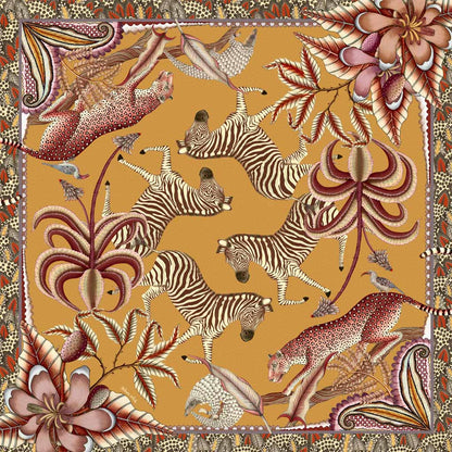 A square tablecloth in warm orange tones, featuring zebras, pangolins, and leopards amid exotic flora, bordered with intricate patterns.
