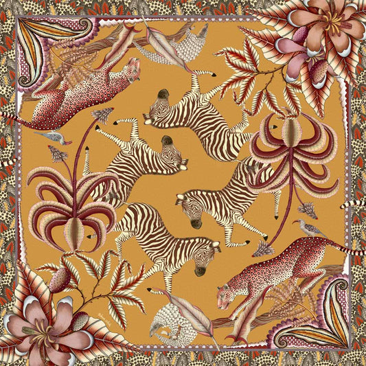 A square tablecloth in warm orange tones, featuring zebras, pangolins, and leopards amid exotic flora, bordered with intricate patterns.